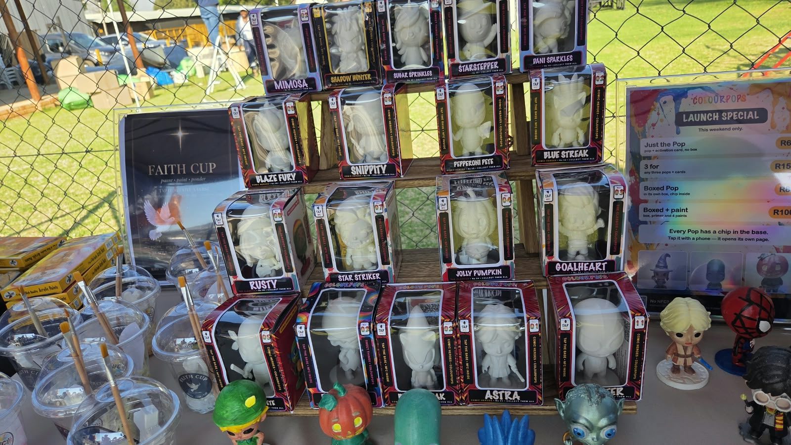 The ColourPops stall at a market: boxed Pops on a shelf, painted figures in front