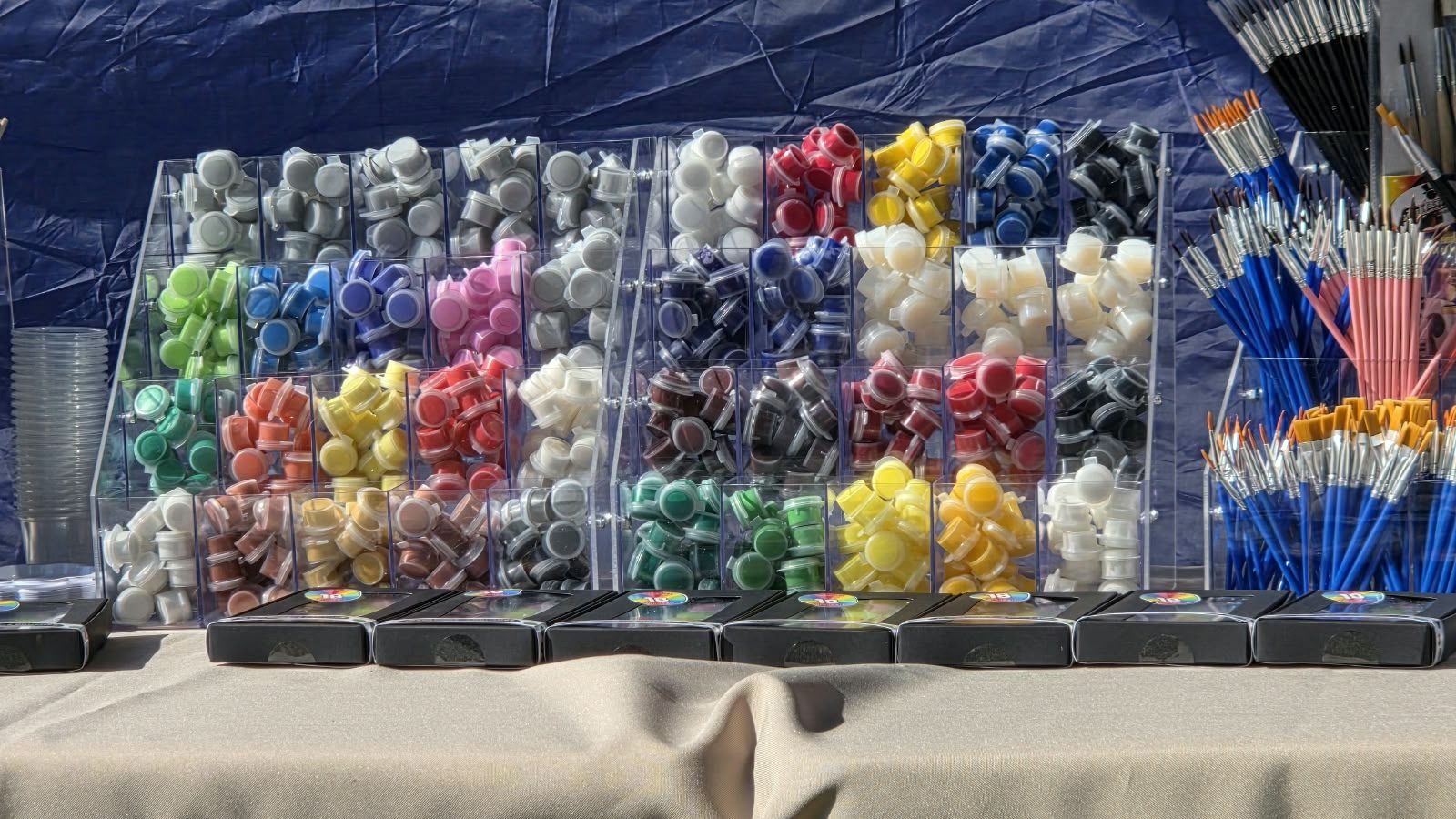 Racks of 2ml ColourPops paint pots in every colour, with brushes alongside